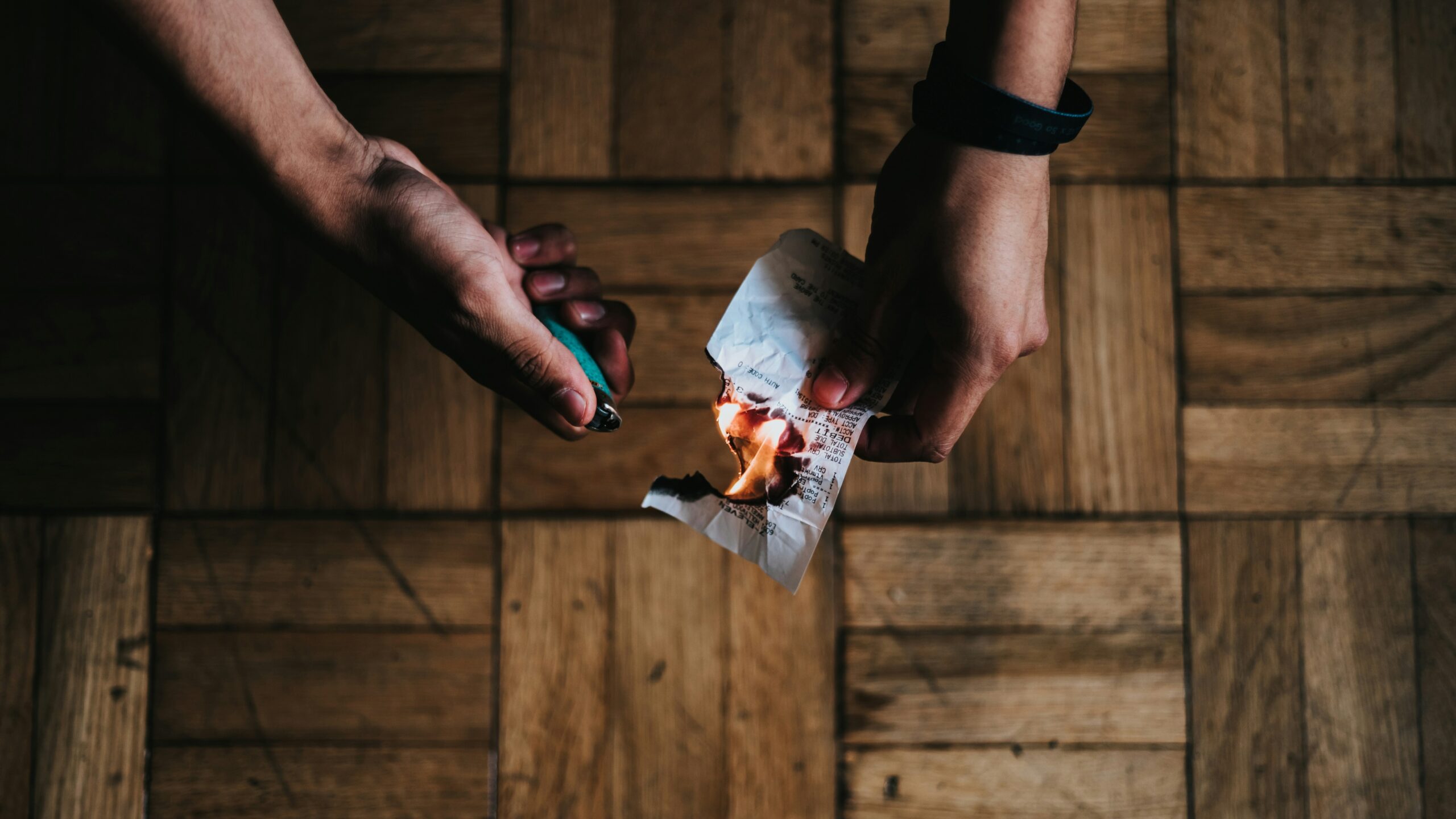 Man lighting a piece of paper (arson illustration) Unsplash