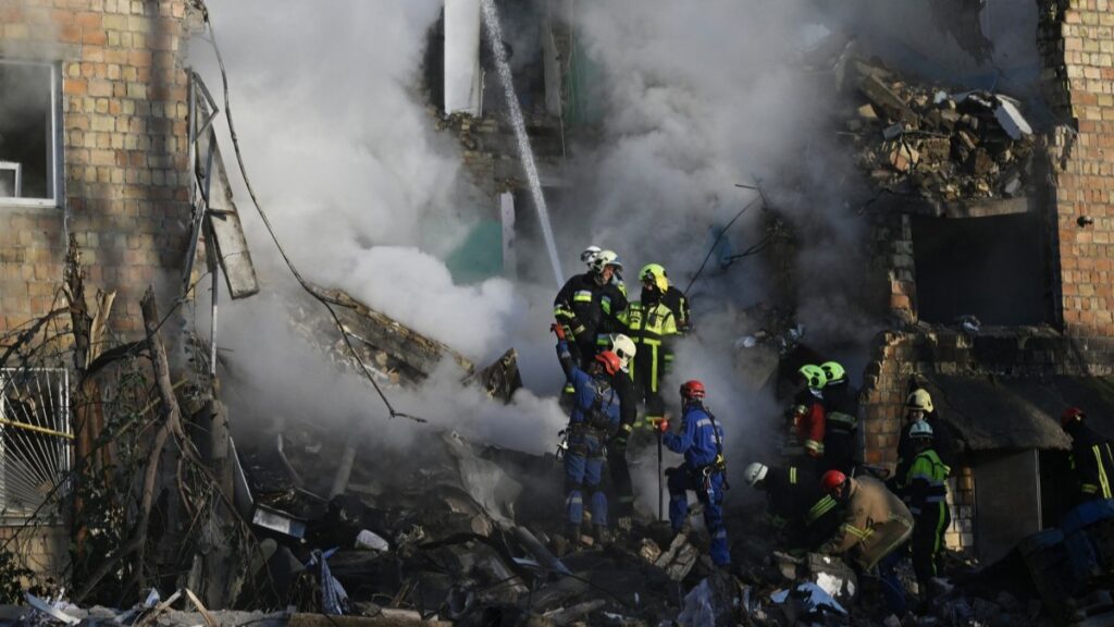 Firefighters conduct a search and rescue mission following a deadly Russian airstrike in Kyiv.