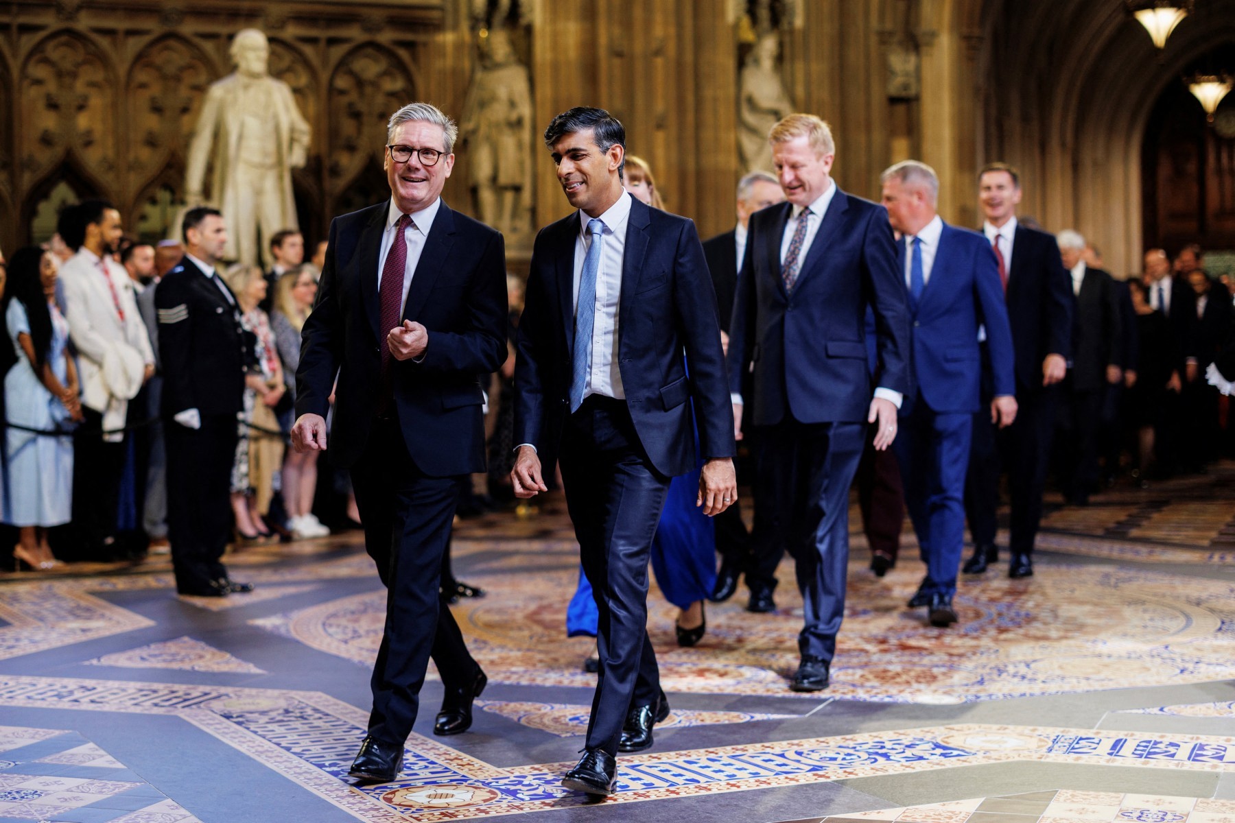 Britain's Prime Minister Keir Starmer (L) and Britain's Conservative Party opposition leader Rishi Sunak (R) speak together as they process through the Central Lobby during the State Opening of Parliament at the Houses of Parliament, in London, on July 17, 2024.