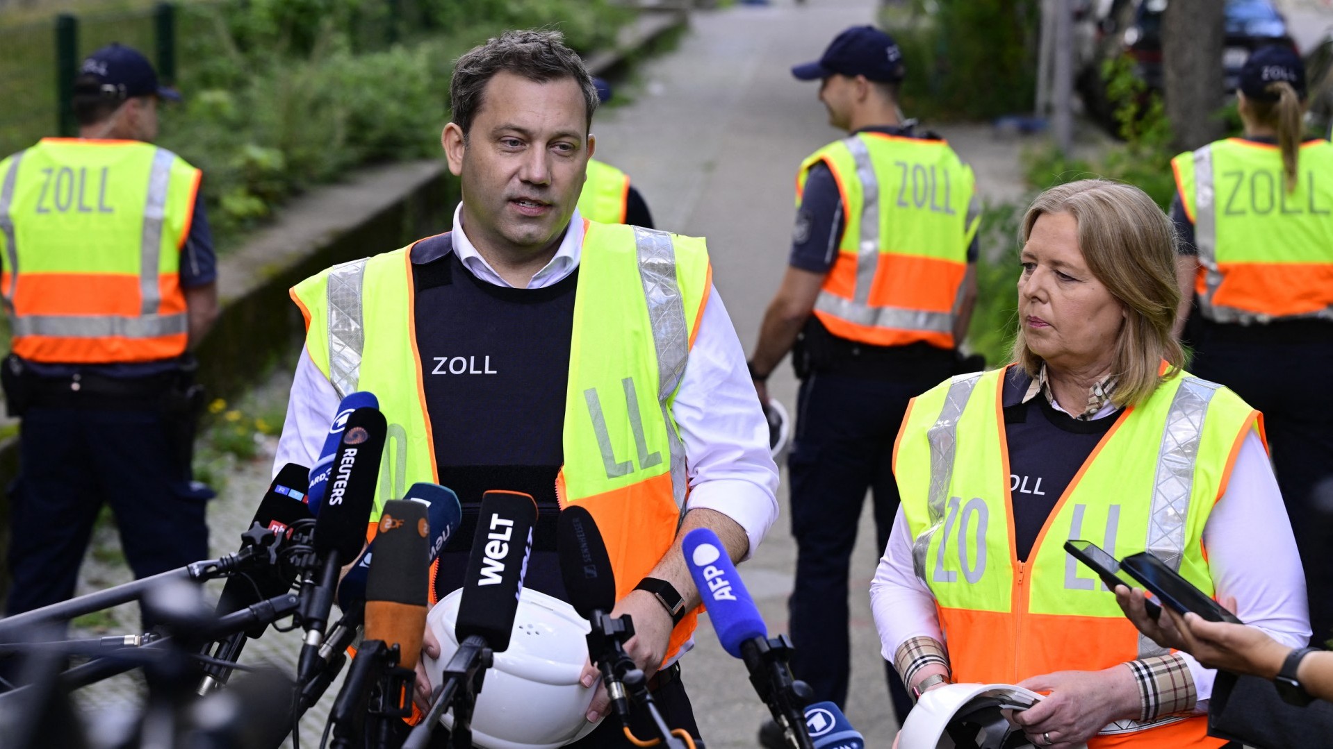 German Finance Minister and Vice Chancellor Lars Klingbeil (L) and German Minister for Labour and Social Affairs Baerbel Bas (R) speak with reporters after witnessing an inspection searching for undeclared workers by the German Customs (Zollamt) at a building site in Berlin, on August 6, 2025.