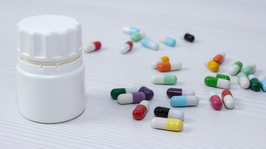 medicine bottle with colorful pills on a table