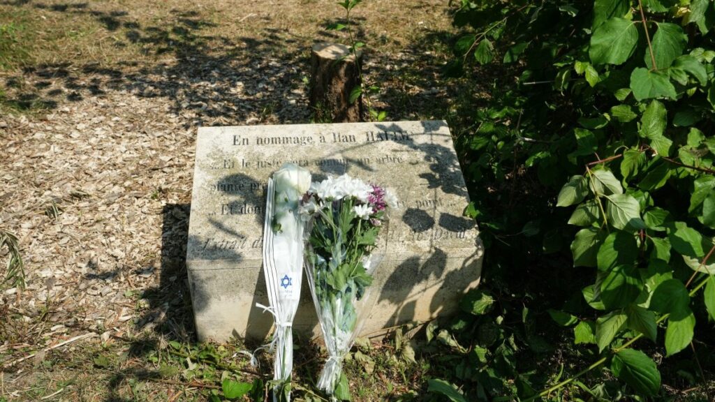 A memorial stele and the trunk of the olive tree, presumably cut down with a chainsaw, planted in 2011 in memory of Ilan Halimi, in Epinay-sur-Seine, on the outskirst of Paris, on August 15, 2025