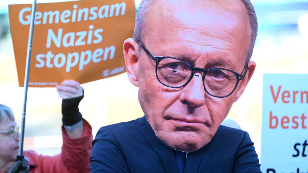An activist wears a mask depicting leader and top candidate for Chancellor of Germany's Christian Democratic Union (CDU) Friedrich Merz during a demonstration organised under the motto 'Tax the Rich' in Berlin, on February 3, 2025.