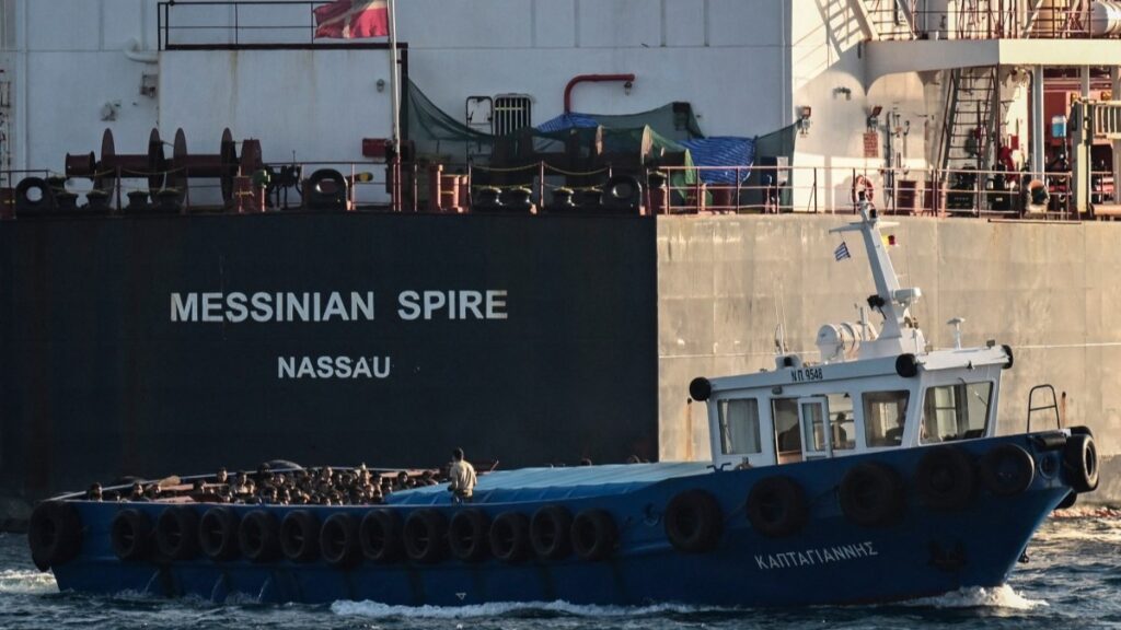 Migrants stand on board a boat after disembarking from a cargo ship before being transferred in the port of Lavrio, south of Athens, on July 10, 2025.