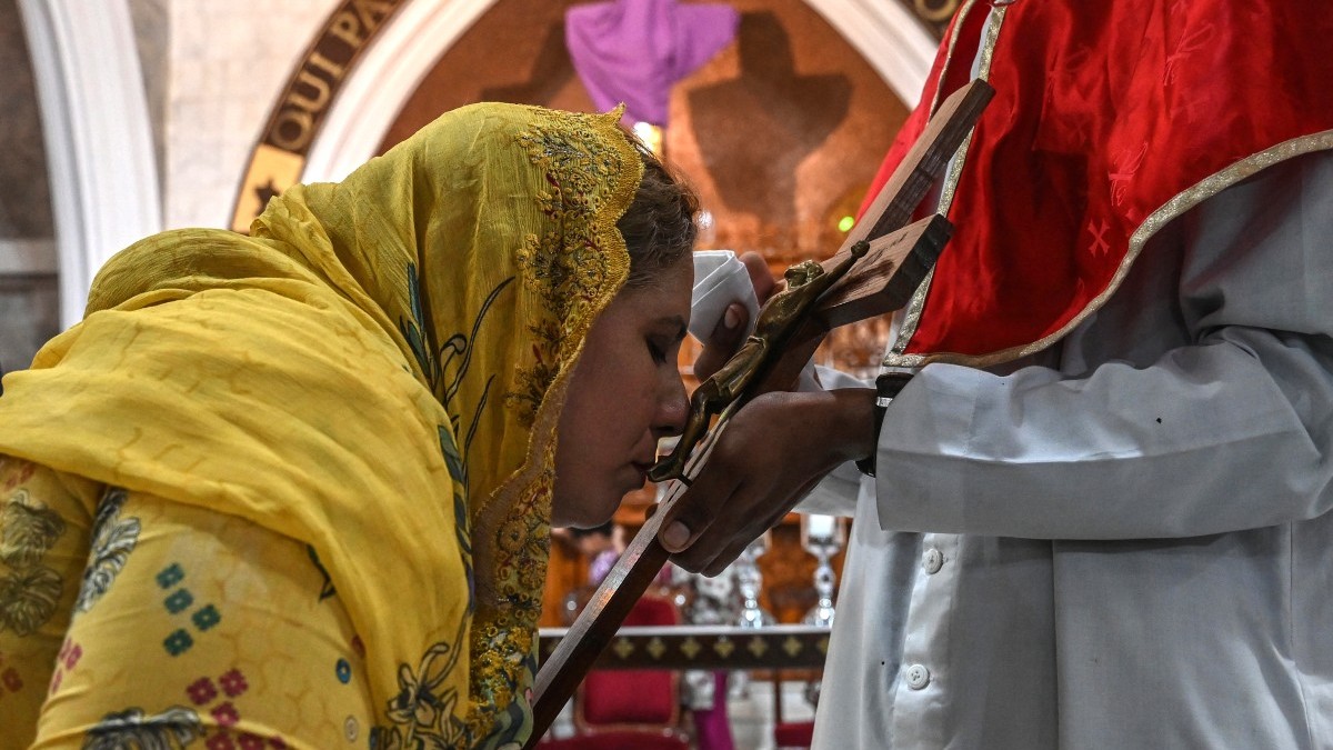 A Christian woman kisses a crucifix during a Good Friday service at St. Anthony's Church in Lahore, Pakistan on April 18, 2025.