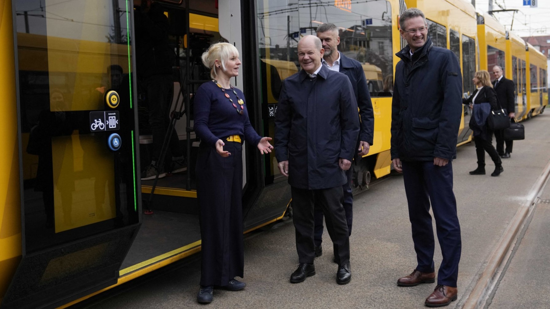 (Former) German Chancellor Olaf Scholz (C) is welcomed by Kristina Kroemer (L), head of the Democracy project 'metro-polis' as he arrives for a tram ride with participants of the group in Dresden, Germany on February 29, 2024.