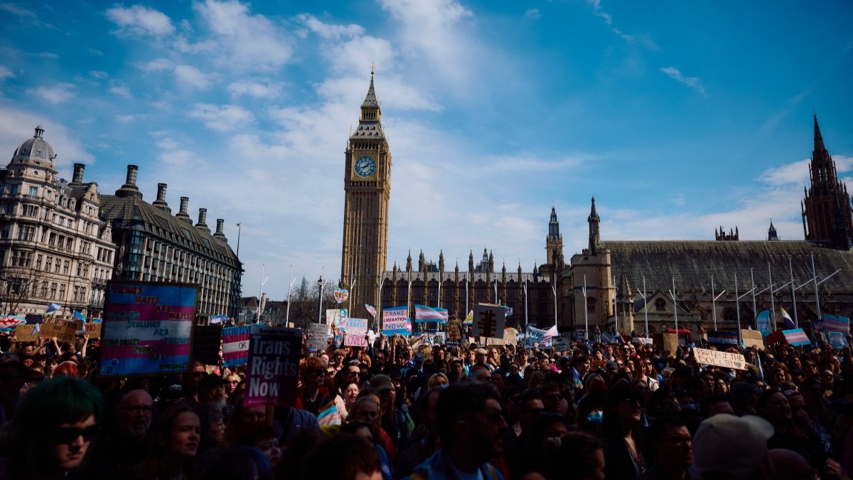Protesters wave flags and hold placards as they gather in Parliament Square in support of “trans rights” in London on April 19, 2025.