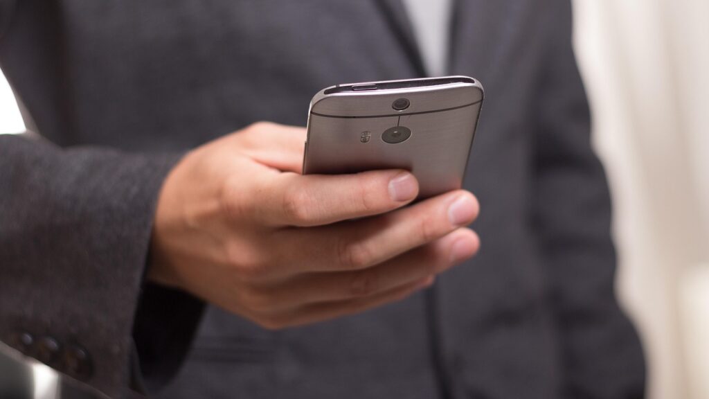 man in suit holding cellphone