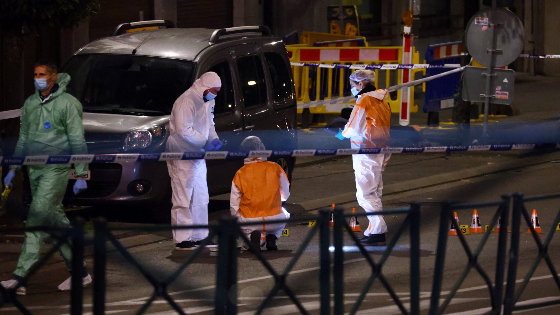 Belgian forensic police search for evidence in a street after two people were killed uring a shooting in Brussels on October 16, 2023