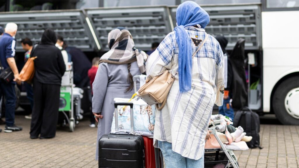 Afghan nationals board a bus after they landed at the airport in Hannover-Langenhagen, northwestern Germany, on September 1, 2025.