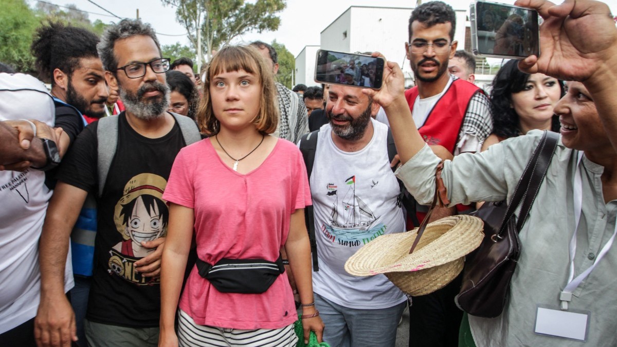Swedish climate activist Greta Thunberg walks with a crowd of pro-Palestinian activists that arrived to greet the Global Sumud Flottila at the port of the village of Sidi Bou Said on September 7, 2025.