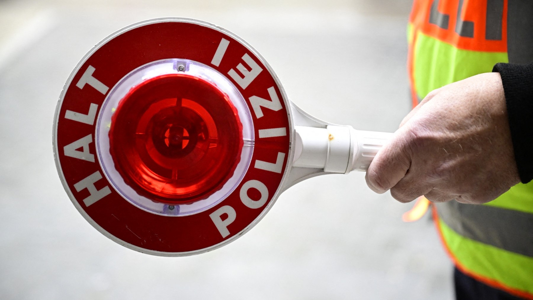 A policeman holds a police signalling disc in Berlin on April 19, 2024.