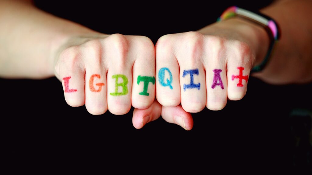 LGBTQI tattoo on fist fingers (Unsplash)