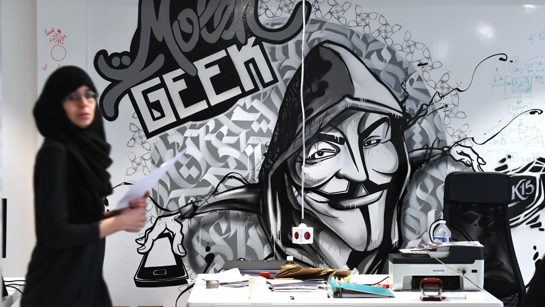 A woman walks past a mural at the Molengeek centre in the Brussels commune of Molenbeek on January 16, 2018.