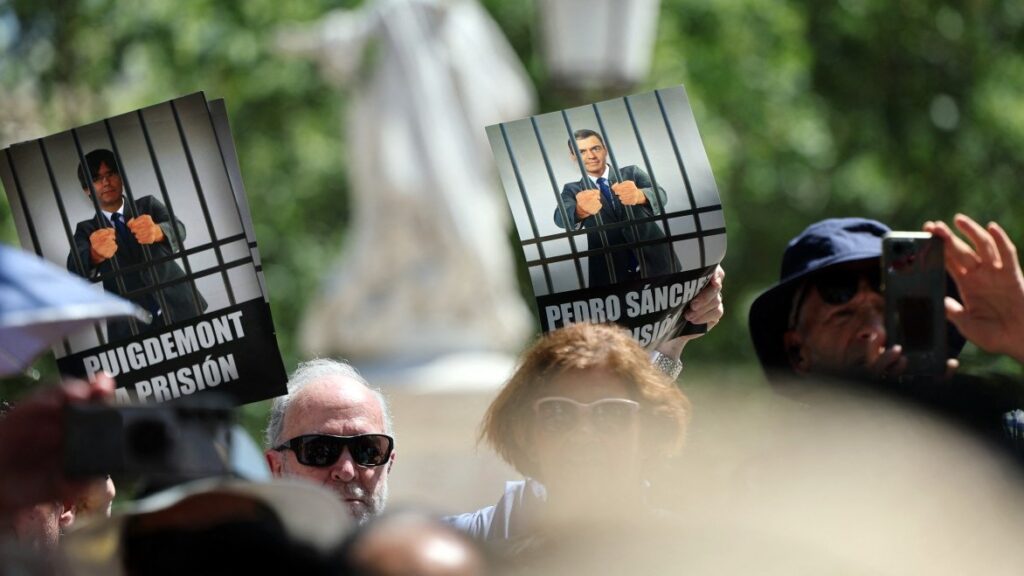 Protestors with banners depicting Spain's Prime Minister Pedro Sánchez and former Catalan regional president Carles Puigdemont during a demonstration called by judges and prosecutors against proposed legislative reforms of judicial careers, on June 28, 2025.