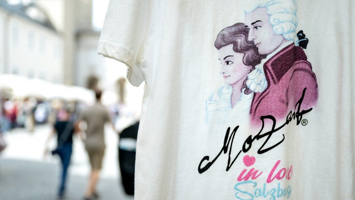 A couple walks past a souvenir shop selling Mozart souvenirs in the historical part of city of Salzburg, Austria on April 16, 2025.