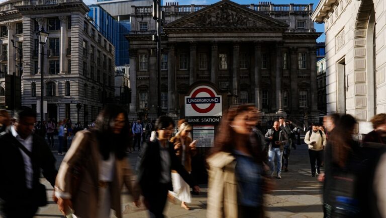fuzzy view of people walking, focus on Bank Street metro station entrance in background