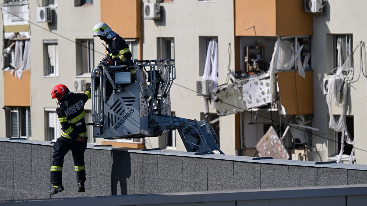 Members of the fire brigade inspect the roof of a school opposite a block of flats were partially destroyed by an explosion in Bucharest, Romania on October 17, 2025.