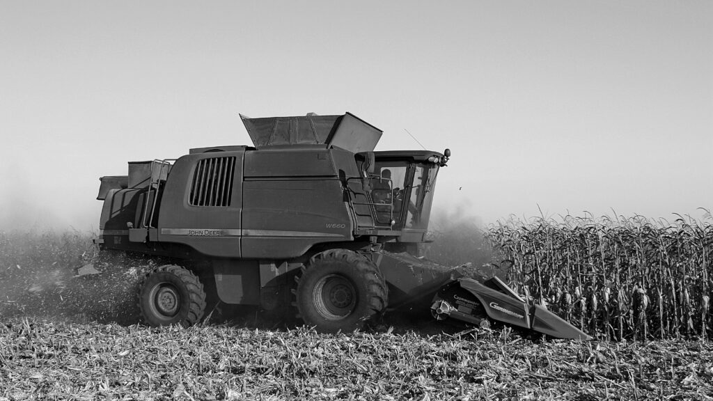 A harvester in a grain field, black and white (Pexels)