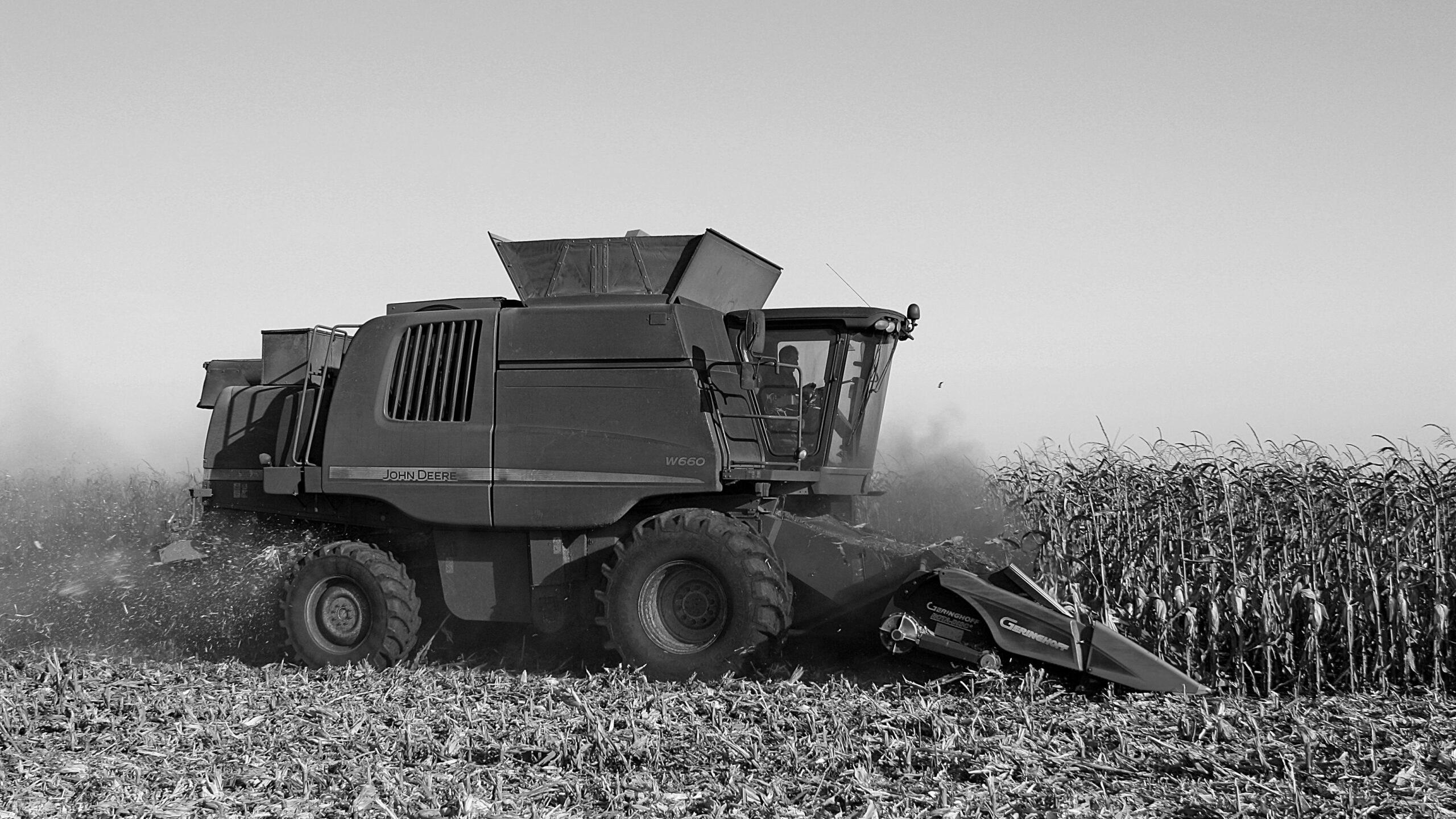 A harvester in a grain field, black and white (Pexels)