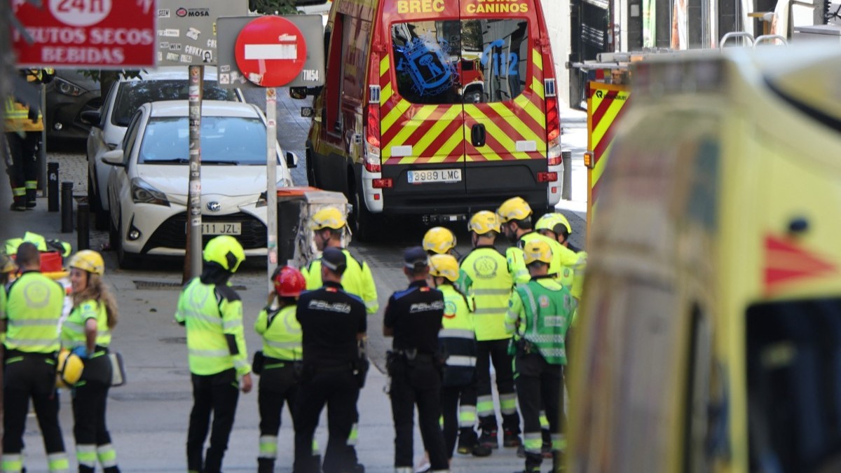 Police and emergency service workers gather near the site of a building collapse in Madrid on October 7, 2025.