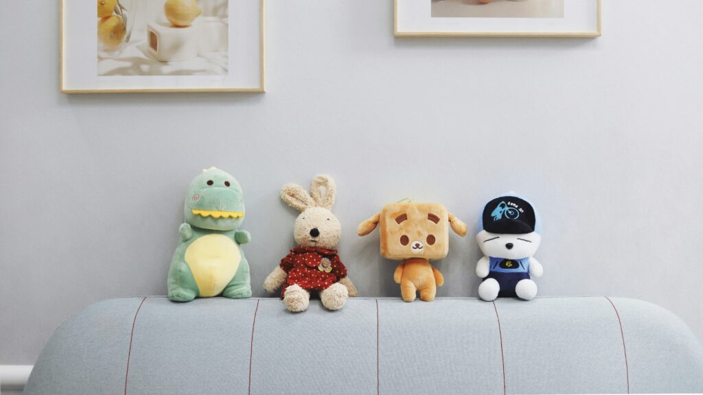 Toys on a sofa with pictures hangng above (Unsplash)