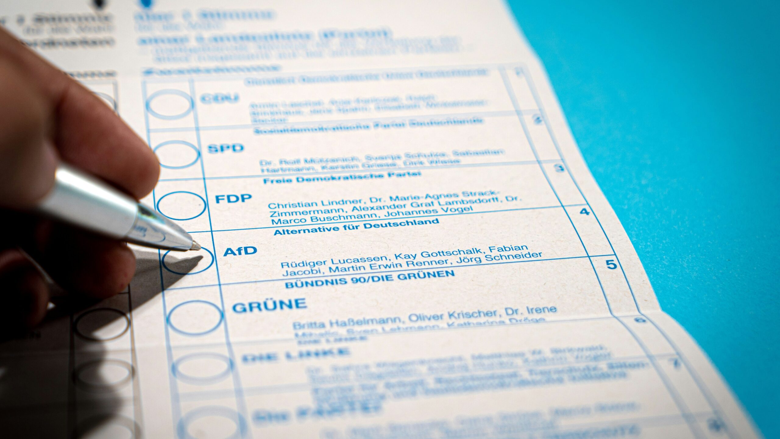 Man with pen about to vote for AfD on paper ballot