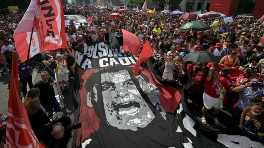 People carry a banner with the image of Brazil's former President Jair Bolsonaro behind bars during a protest against a constitutional amendment that requires Congress to authorize any criminal charges against deputies and senators through a secret vote, in São Paulo on September 21, 2025.