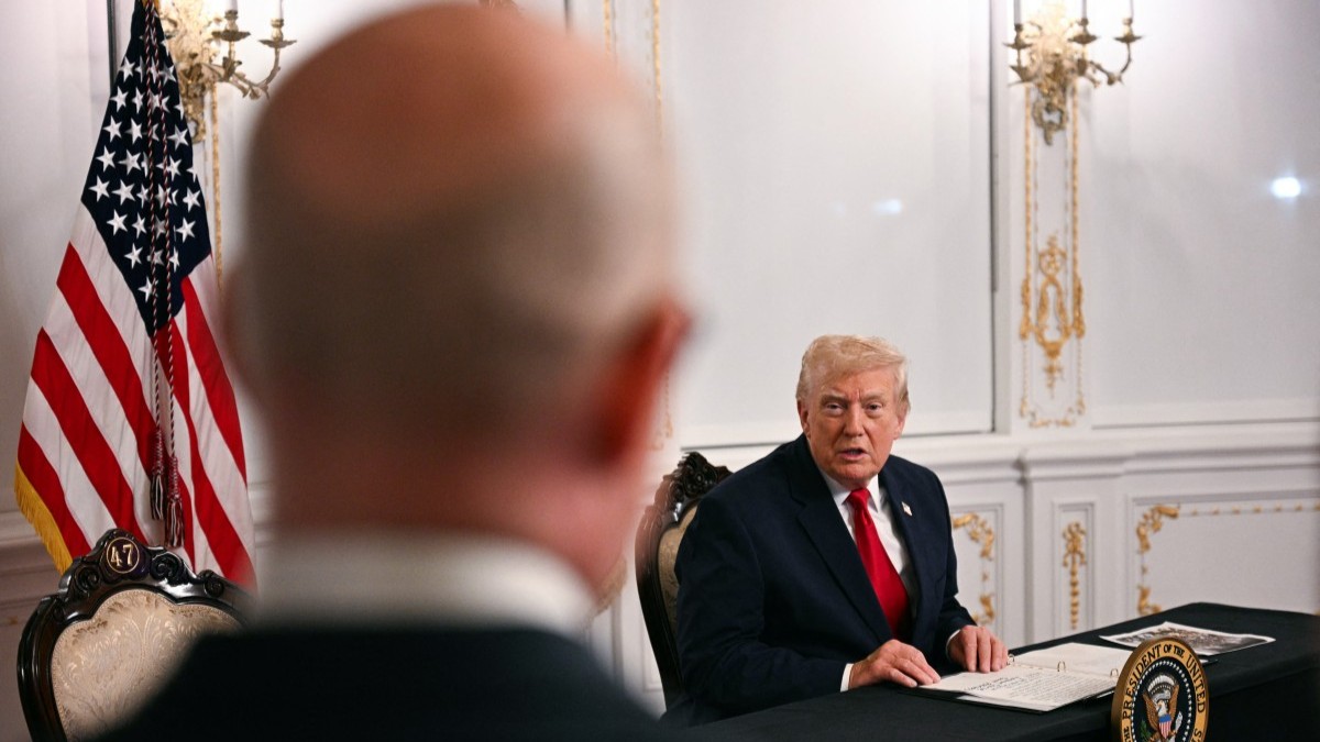 U.S. President Donald Trump answers a question from a reporter while participating in a video call with military service members from his Mar-a-Lago residence in Palm Beach, Florida, on November 27, 2025, during the Thanksgiving holiday.