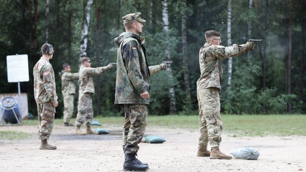 A Bundeswehr non-commissioned officer observes U.S. Army soldiers firing during a German Armed Forces Proficiency Badge qualification at a training area in Germany in 2019.