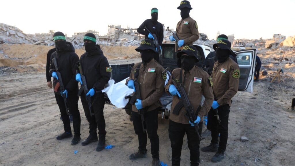 Islamic Jihad and Hamas terrorists with a white body bag believed to carry the remains of an Israeli hostage in the town of Beit Lahia in the northern Gaza Strip on December 3, 2025.