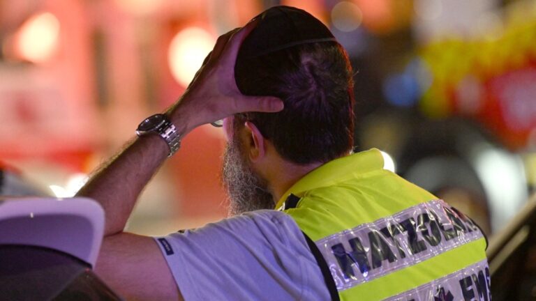 A member of the Jewish community stands at the site of the Bondi Beach shooting in Sydney on December 14, 2025.