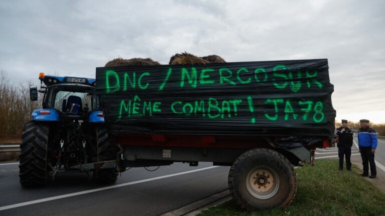 A sign on a tractor at a farmers’ protest outside Paris reads "DNC / Mercosur, same battle" on December 16, 2025, as part of nationwide action by farmers to protest against the government's mandatory culling protocol for cattle affected by lumpy skin disease (dermatose nodulaire contagieuse).