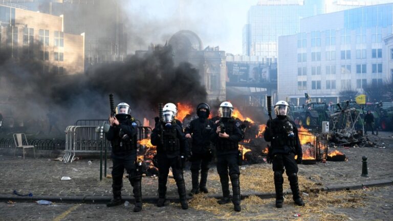 Riot police officers look on after a farmers' protest n Brussels on December 18, 2025