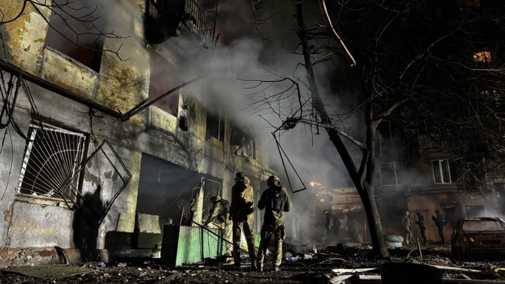 Law enforcement officers work in the courtyard of a damaged residential building following an air attack in Zaporizhzhia on November 25, 2025.
