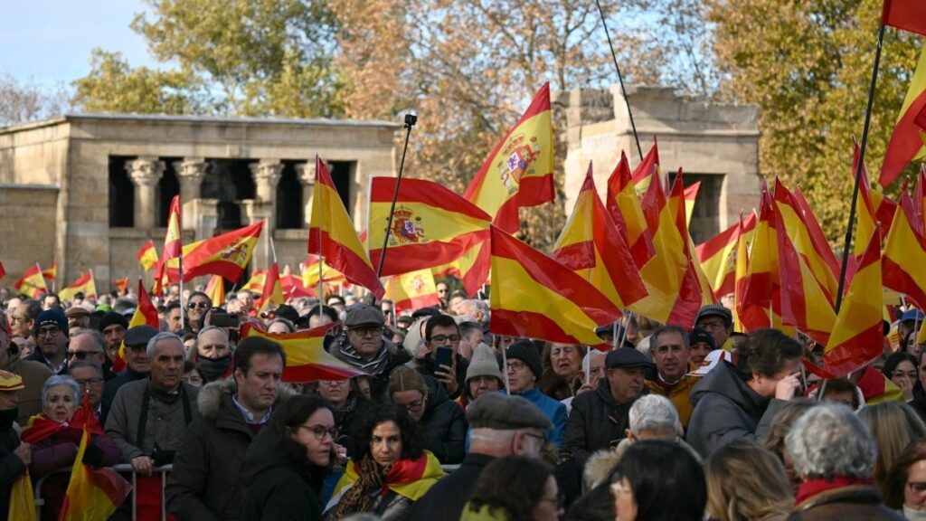 Protestors hold Spanish flags during a demonstration against corruption called by the right-wing opposition party Partido Popular (PP) in Madrid on November 30, 2025.