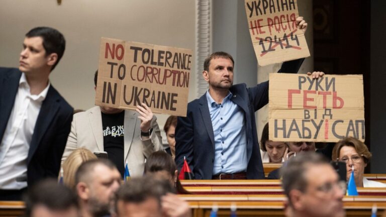 Ukrainian lawmakers protest with placards as they vote on a bill to replace a law that curbed the powers of anti-graft bodies in Kyiv on July 31, 2025.