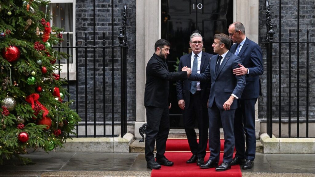 Ukraine’s President Volodymyr Zelensky (L) shakes hands with French President Emmanuel Macron (2nd R) as UK Prime Minister Keir Starmer (2nd L) and German Chancellor Friedrich Merz (R) look on following their meeting at Number 10 Downing Street in London on December 8, 2025.