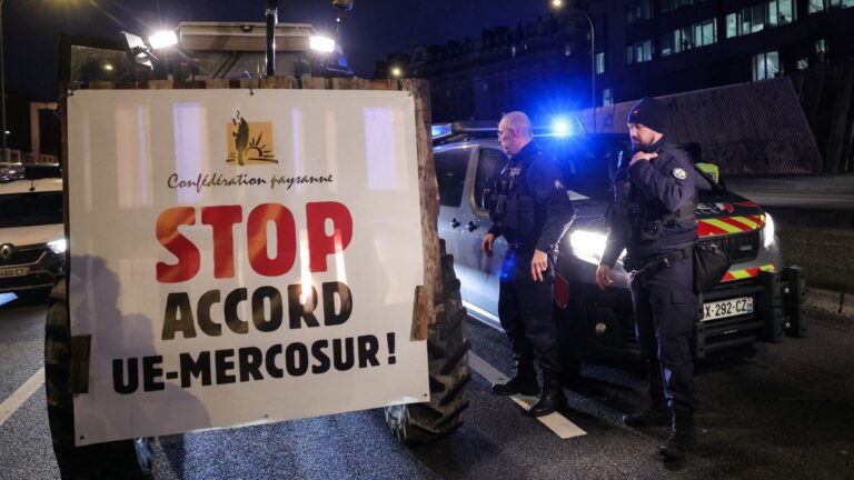 A member of the Confederation Paysanne farmers union drives his tractors with a placard reading "Stop the EU-MERCOSUR Agreement" as they take part in a protest to push France's government to block the Mercosur trade deal, in Paris on January 9, 2026.