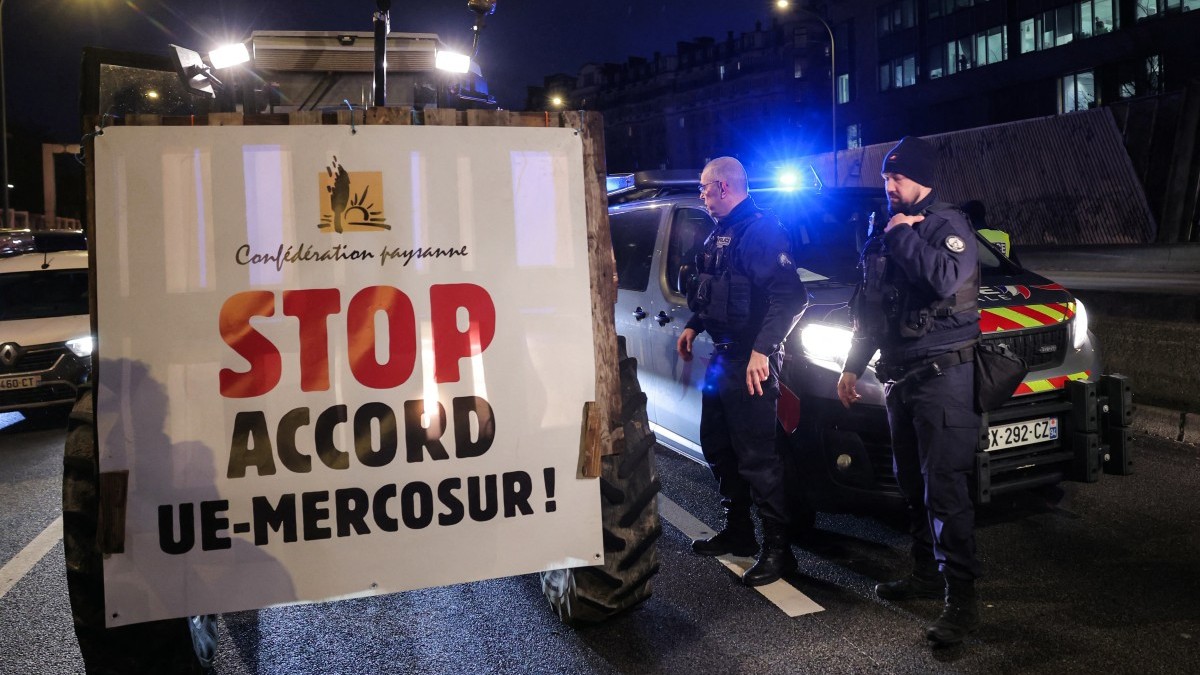 A member of the Confederation Paysanne farmers union drives his tractors with a placard reading "Stop the EU-MERCOSUR Agreement" as they take part in a protest to push France's government to block the Mercosur trade deal, in Paris on January 9, 2026.