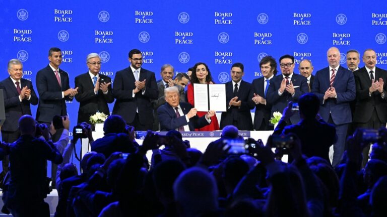 Donald Trump (sitting) and the other signatories hold a signed founding charter at the Board of Peace meeting during the World Economic Forum (WEF) annual meeting in Davos on January 22, 2026.