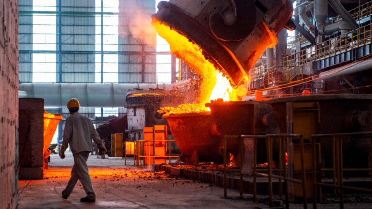 A worker walks past molten steel at a steel factory in Huai’an, in China’s eastern Jiangsu province on July 22, 2025.