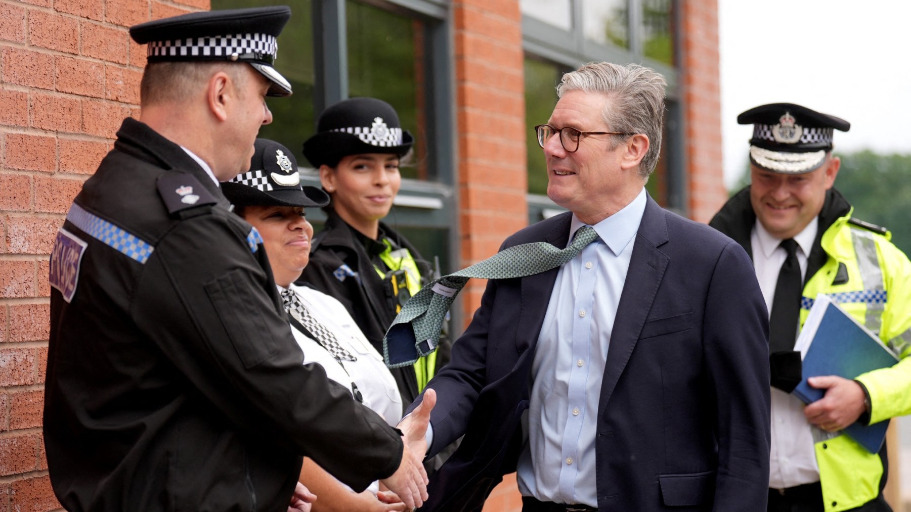 UK Prime Minister Keir Starmer (C) arrives with West Midlands Chief Constable Craig Guildford to greet members of the West Midlands Police Force at Arden Academy in Solihull, West Midlands, on August 8, 2024.