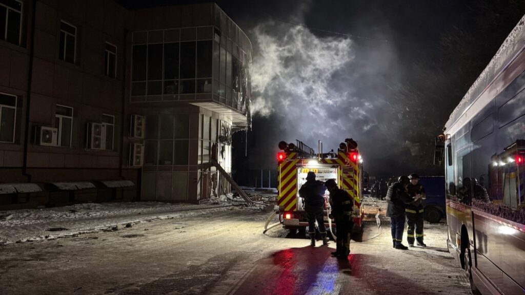 Firefighters stand near a damaged residential building following a Russian drone strike in Zaporizhzhia on January 2, 2026.