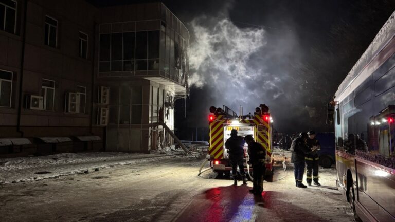 Firefighters stand near a damaged residential building following a Russian drone strike in Zaporizhzhia on January 2, 2026.
