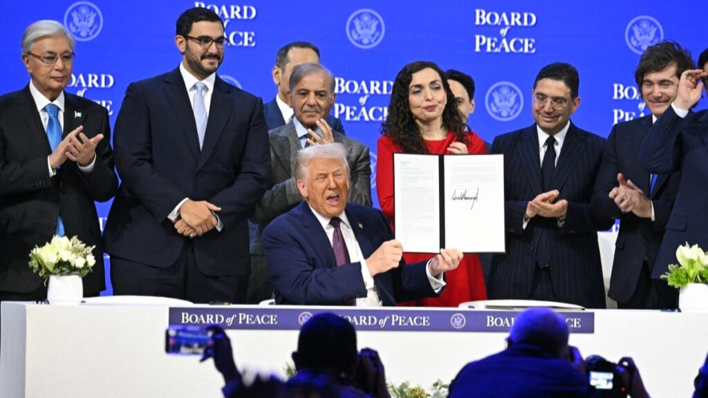 U.S. President Donald Trump (C) holds a signing founding charter at the Board of Peace meeting during the World Economic Forum (WEF) annual meeting in Davos on January 22, 2026.