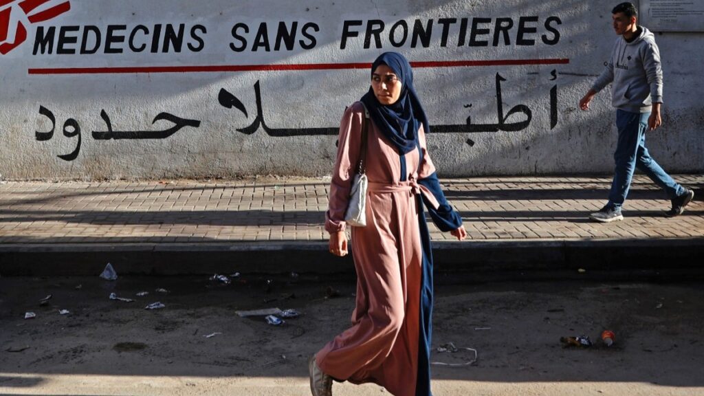 Palestinians walk past the clinic of Doctors Without Borders (Médecins Sans Frontières (MSF), in the al-Rimal neighborhood of Gaza City on January 11, 2026.