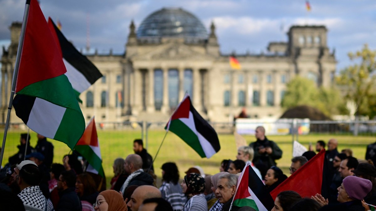 Pro-Palestinian protesters demonstrate on October 11, 2025 in front of the Reichstag building housing the Bundestag in Berlin, Germany.