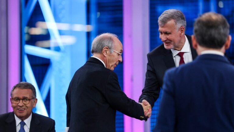 PP candidate Luís Marques Mendes (C) greets independent candidate Admiral Henrique Gouveia e Melo (R) next to Socialist Party candidate Antonio José Seguro before a TV debate with the rest of presidential candidates ahead of the January 18 election, in Lisbon on January 6, 2026.
