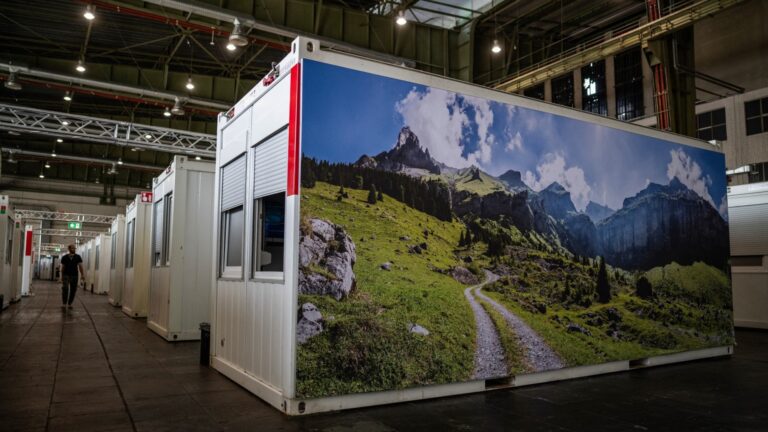 A container is decorated with a poster featuring a green landscape in a container facility for refugees and asylum seekers located in aircraft hangars of the former Tempelhof airport in Berlin on August 14, 2025.
